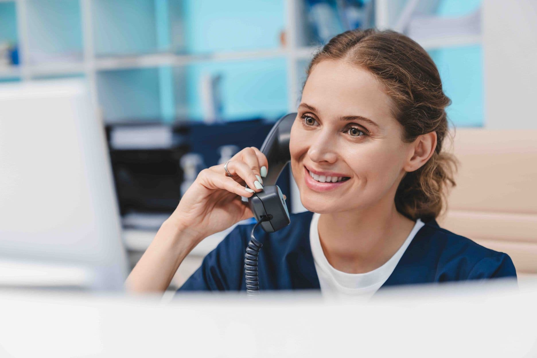 Mitarbeiterin der Terminvereinbarung am Telefon